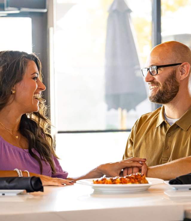 Couple enjoying drinks and an appetizer during a romantic evening at Angelina's Kitchen.
