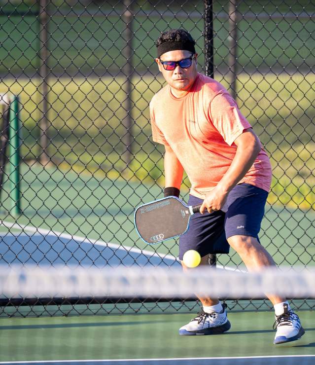 Pickleball player at Pioneer Park in Woodbury during a warm day.