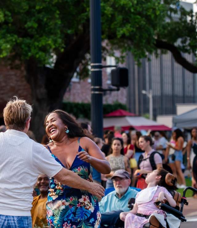 couple dancing in the street as a crowd of people watches in Downtown Lake Charles