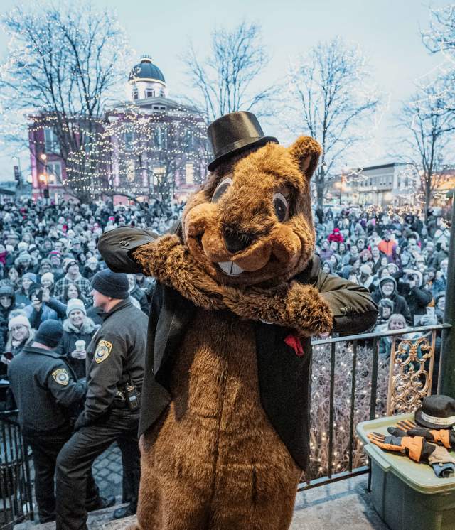Woodstock Willie with Top Hat holding his head in his hands behind a crowd
