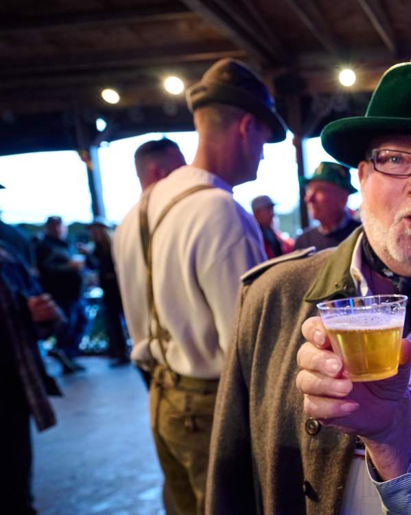 Two men dressed in traditional Bavarian style raise a glass to Reading Liederkranz Oktoberfest.