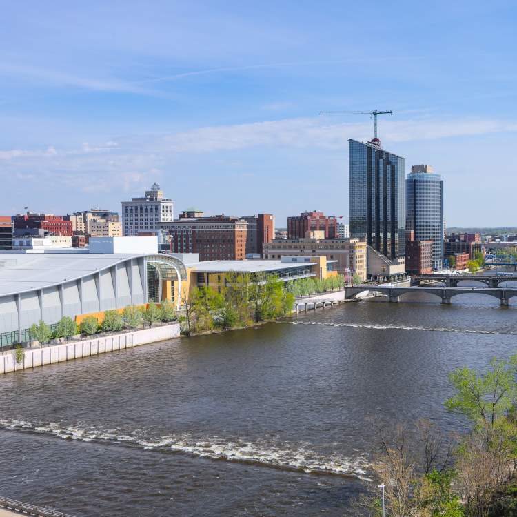 Skyline: 2019. Showcases convention center and downtown hotels off of the Grand River. Developments on the Amway Grand Plaza Hotel roof.
