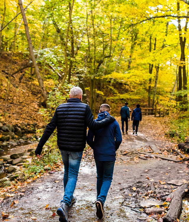 family walking on trail with fall colors surrounding