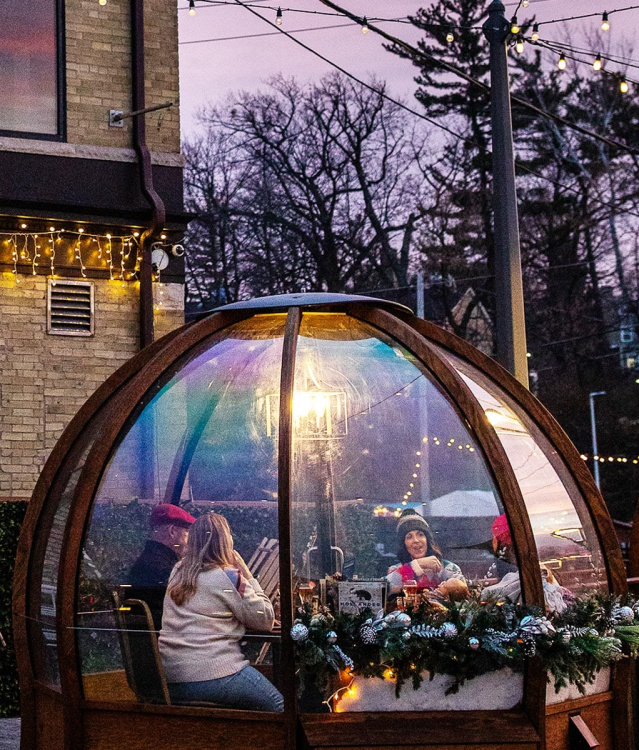 friends eating in a winter dome outside Cafe Hollander in wauwatosa