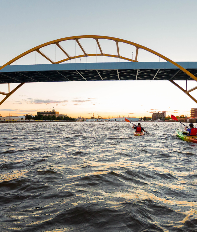 two kayakers kayaking under the Hoan Bridge