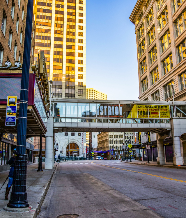 an image of a city street with a theater marquee and a skywalk with Milwaukee Theater District branding