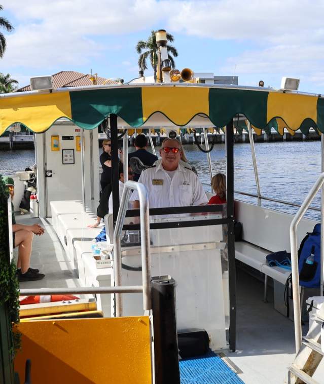 A captain and first mate posing for a photo with the Water Taxi from a stop on the Intracoastal Waterway