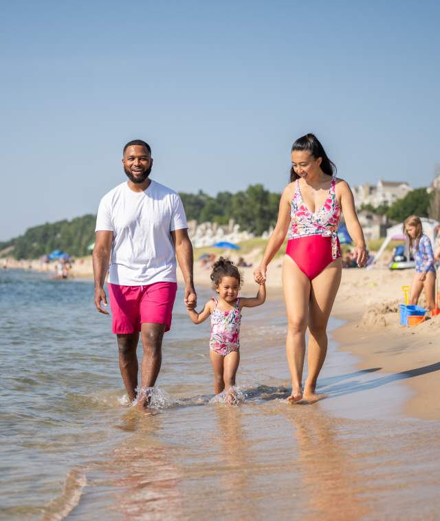 Family walking along the water at Holland State Park