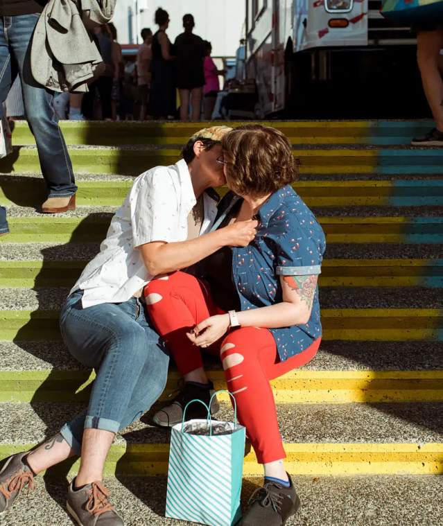 Two people kissing on stairs.