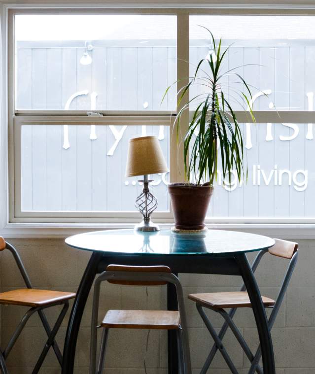 Three chairs and a table by a window.