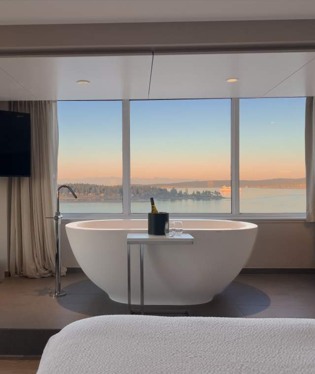 A large bath tub with a sunset view.