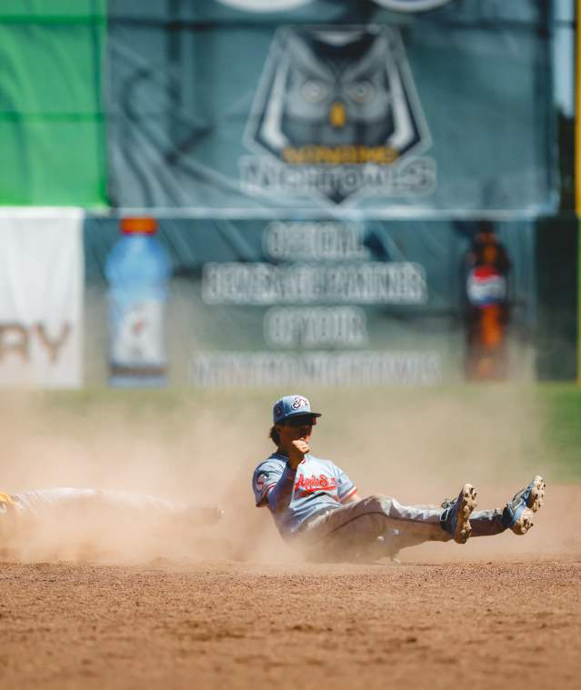 A baseball player sliding to a base.