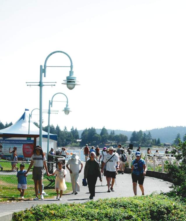 People walking on a path by the ocean.