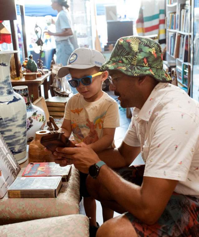 A relaxed moment inside a Nanaimo vintage shop, where an adult and child explore together among shelves of unique antiques and collectibles.