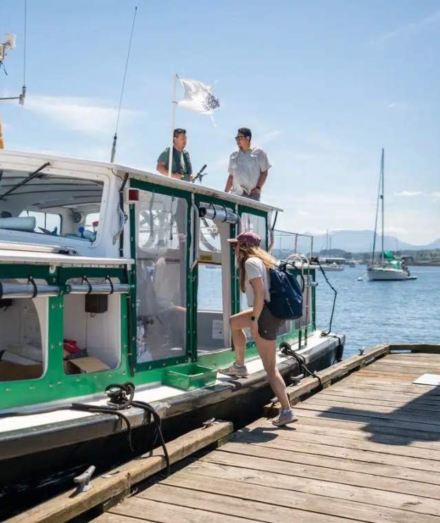 A person boarding a small ferry.