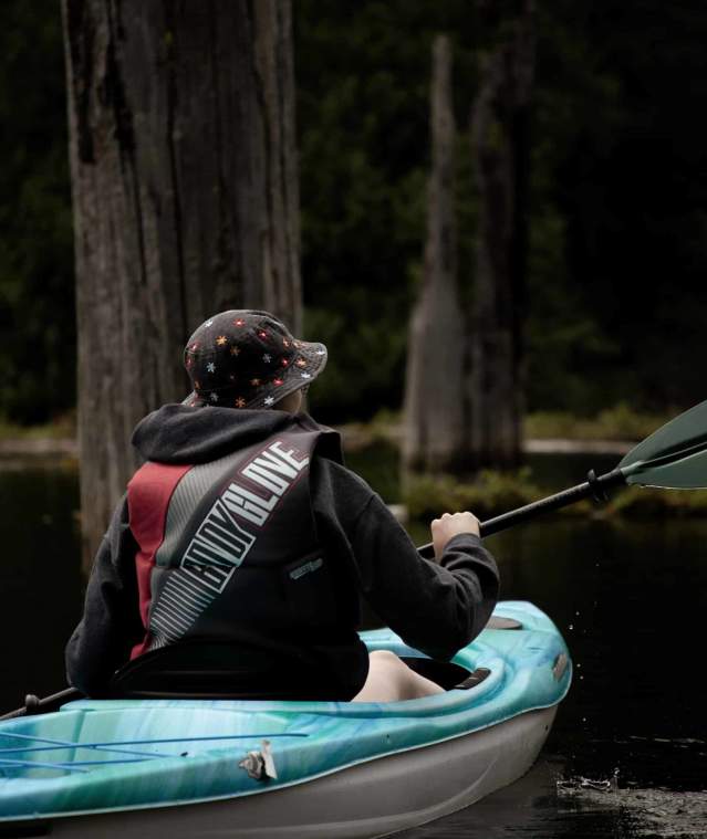 A person kayaking in a drowned forest.