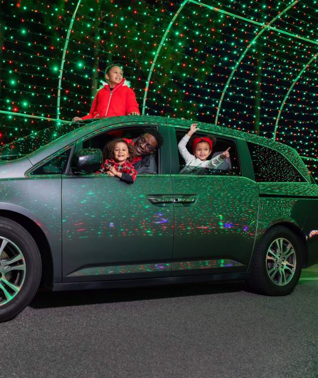 A family in a car enjoying The Great Christmas Light Show