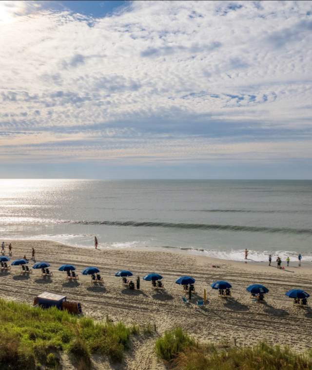 A Beach with Chairs on a sunny day with white clouds
