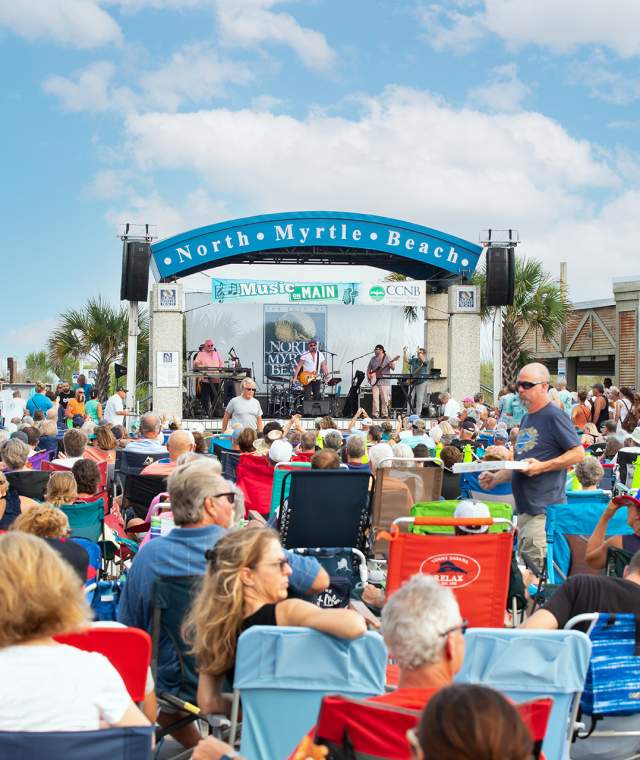 A crowd enjoys music on Main on a sunny day.