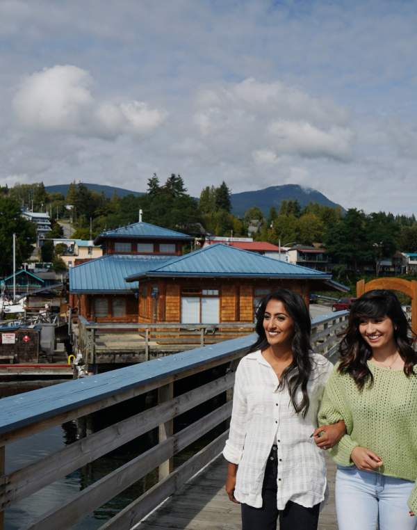 Two woman walk arm-in-arm in Gibsons.