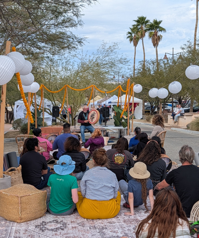 Attendees watching a drum performance at the Holistic Health Fair at the Historic Plaza in Twentynine Palms, California.