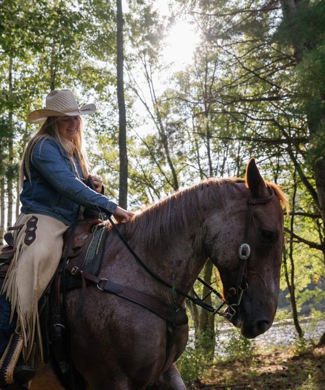Woman horseback riding at 1000 Acres Ranch