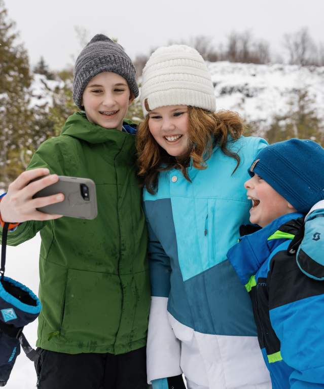 Siblings stop snowshoeing to take a selfie