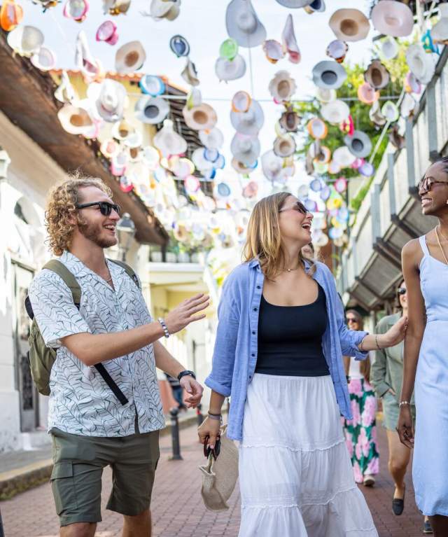 Turistas recorriendo una calle decorada con sombreros en el Casco Antiguo de Ciudad de Panamá