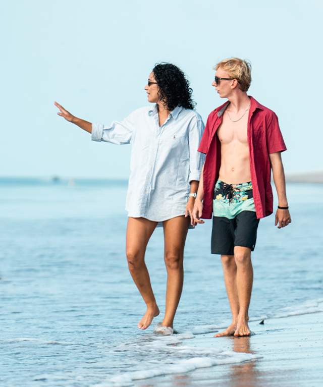 Friends leisurely walk along the sandy beach of Buenaventura
