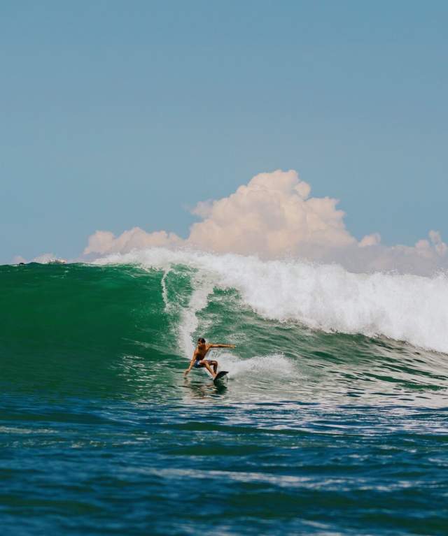 Surfista maniobrando una gran ola en Panamá con mar azul intenso