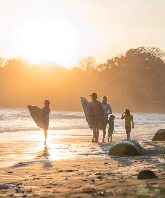 Sunrise view of surfers walking on the coast of Estero Beach at Santa Catalina
