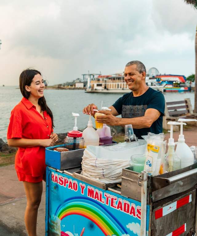 Tourist buying a raspado from a street vendor on the Amador Causeway in Panama City.