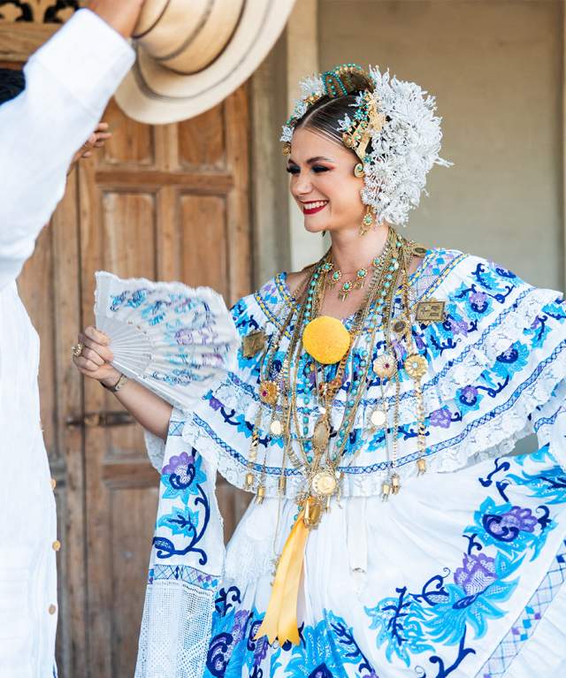 Dressed with typical panamanian clothes Pollera de Gala white fabric with blue embroider blue flowers