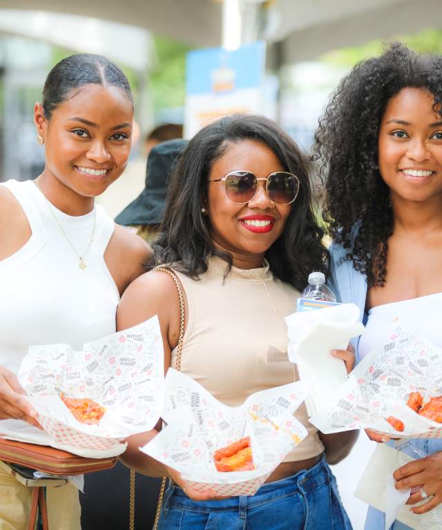 Three women holding baskets of food.