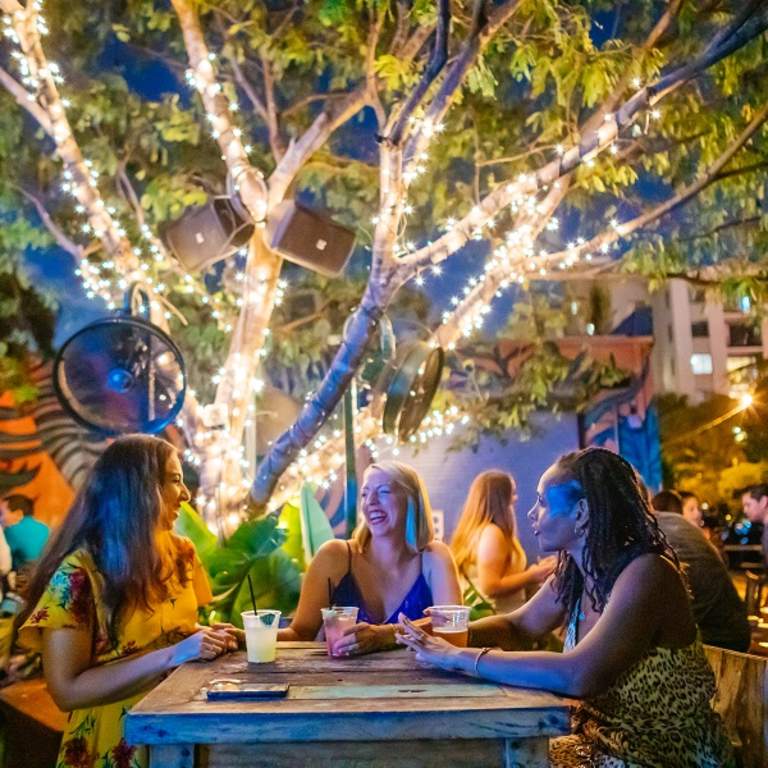 Three ladies enjoying drinks in the outdoor area of Rhythm & Vine