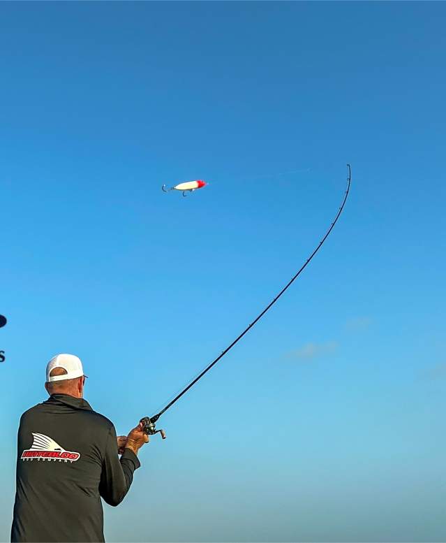 Man casting a line over the water. Blue Deep Sea Roundup logo overlaid on the sky.