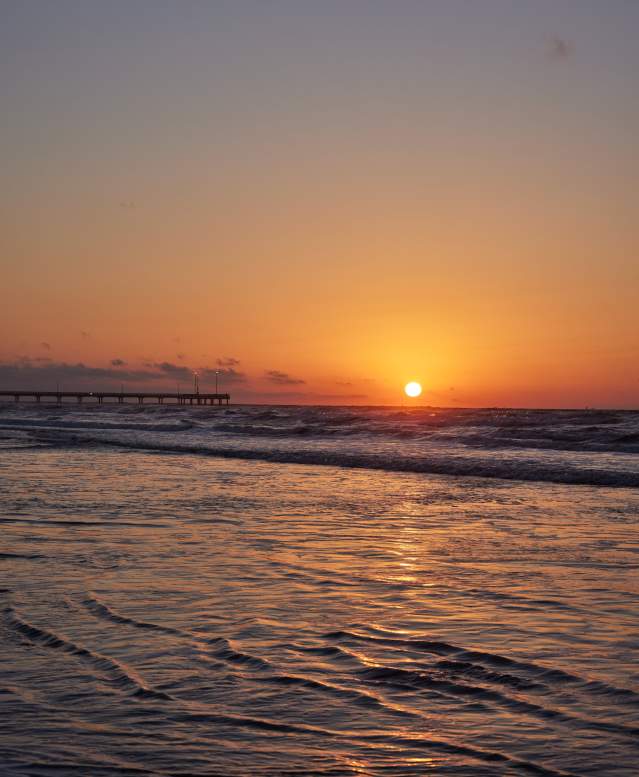 Sunrise on the beach over the water