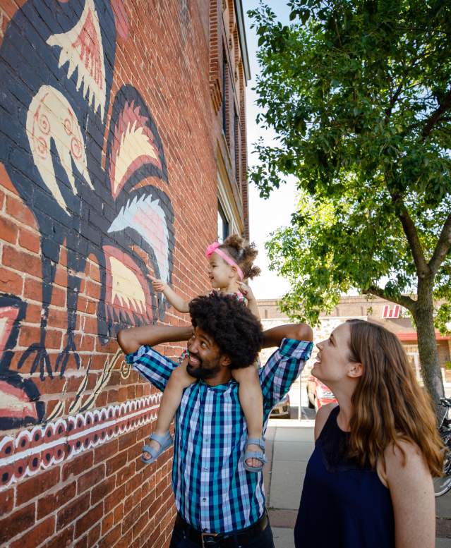 Family exploring downtown mural of Polish Chickens