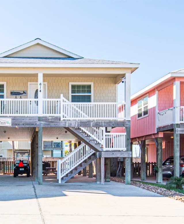Tan beach house on stilts with a golf cart underneath