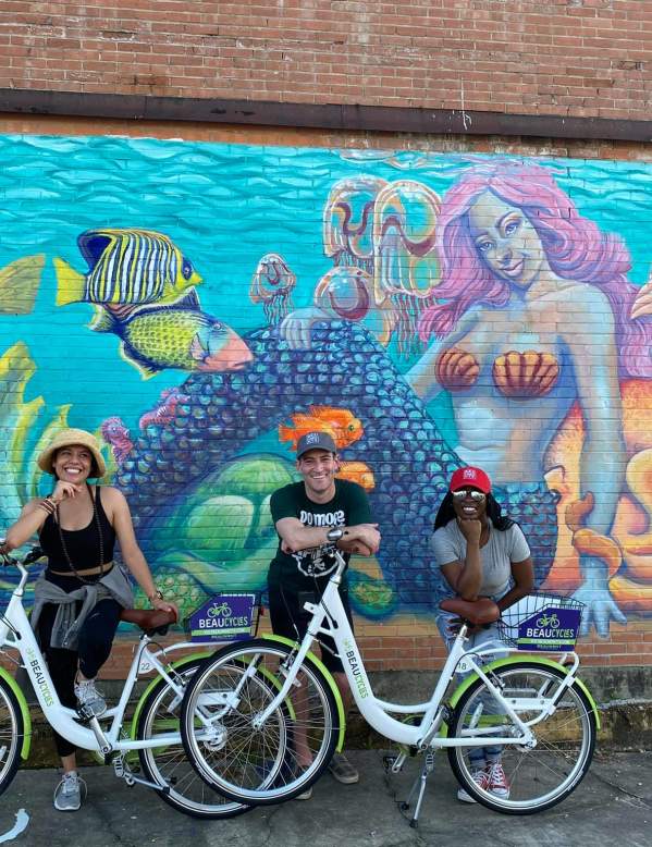 People In Beaumont TX On Their Beaucycles in front of a mural