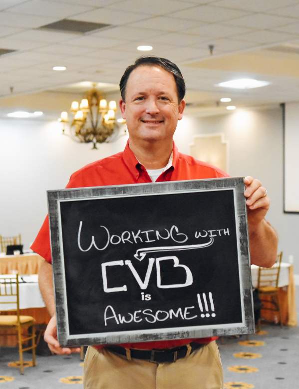 Man holding a Working with CVB is Awesome sign
