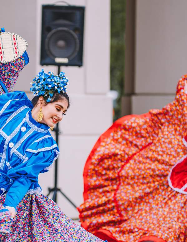 Two girls in traditional dress dancing folklorico