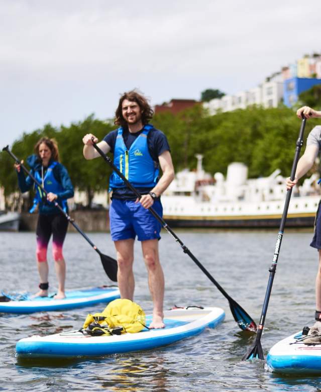 People stand up paddleboarding in Bristol harbour