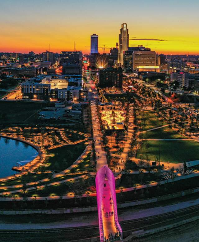 A vibrant sunset skyline shot of Omaha, Nebraska showing pink lights from Heartland of America Park and Farnam Pier.