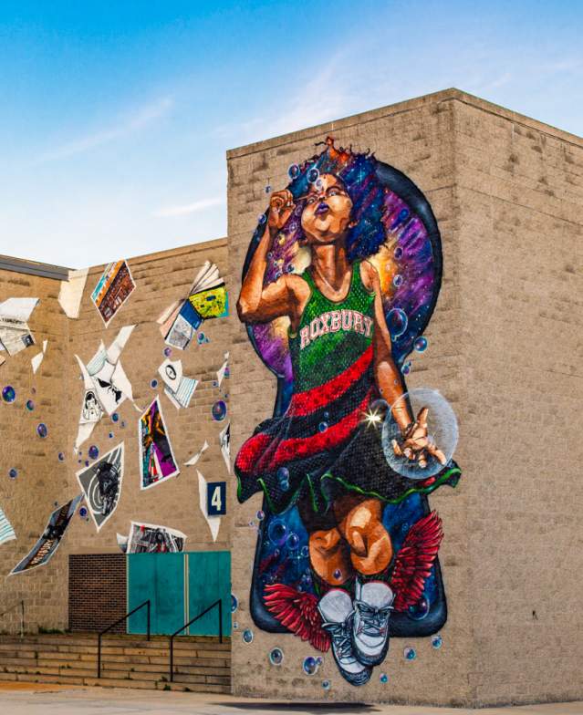 Mural depicting child wearing a dress reading Roxbury blowing bubbles and surrounded by blowing posters and books