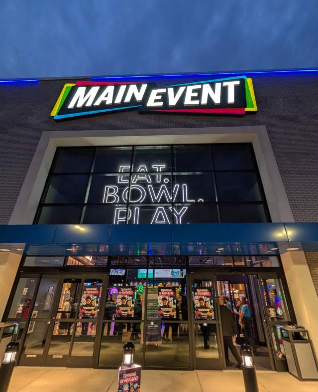 Main Event preview opening in Woodbury showing exterior signs lit up with "Eat. Bowl. Play"