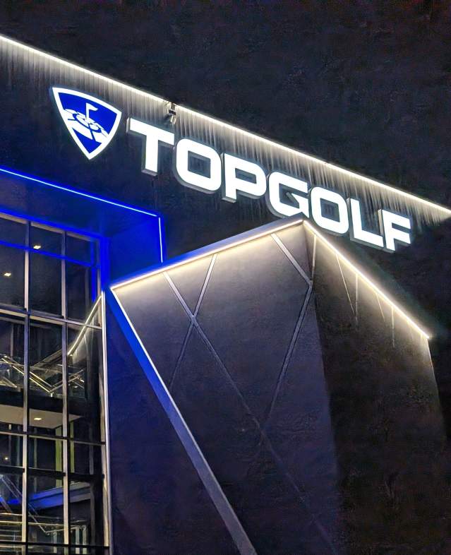 Topgolf Woodbury in the evening showing the building lights