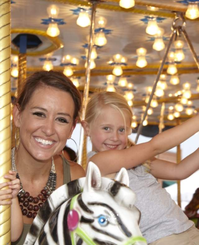 Mother and daughters riding a carousel