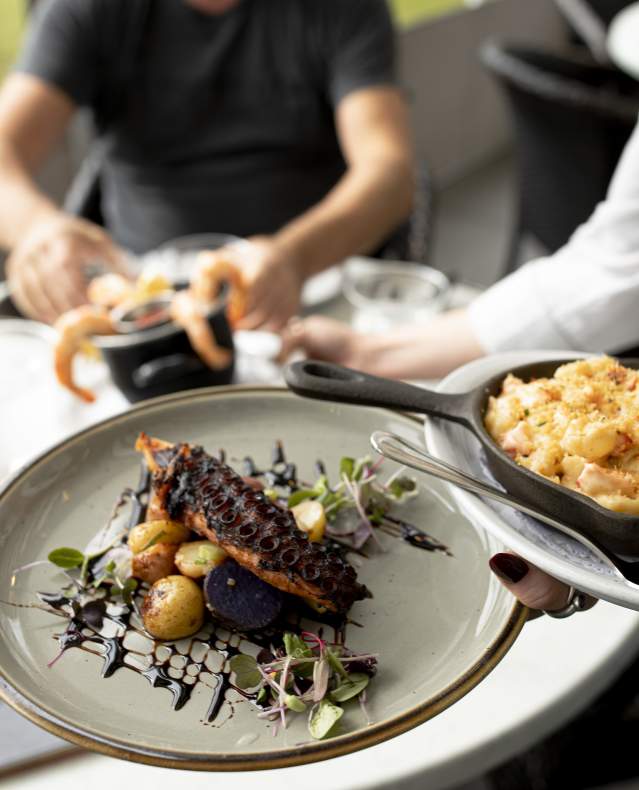 A waitress serves two plates of food to a table.