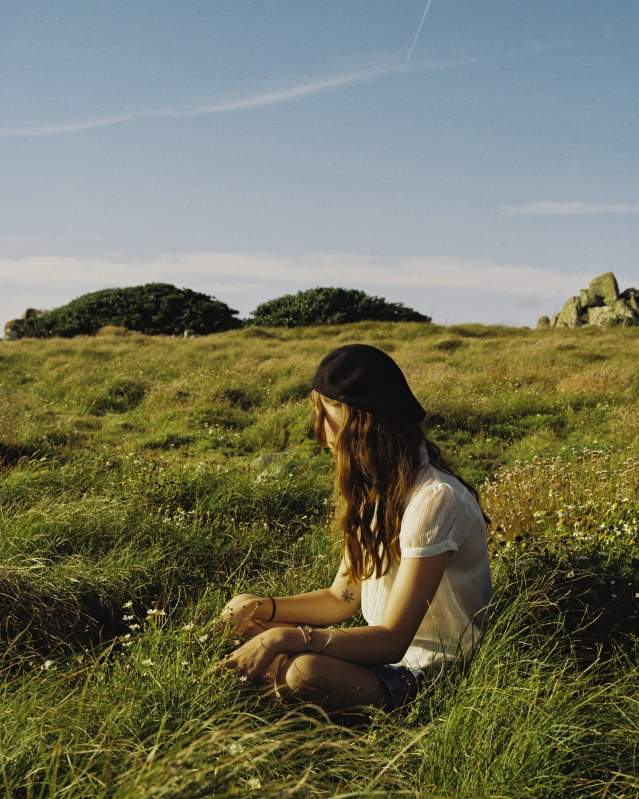 Girl sitting on grass in Autumn
